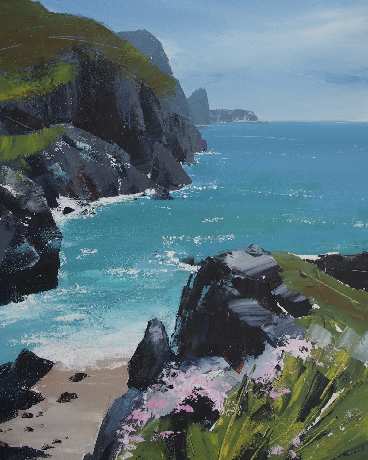 A landscape painting of a rocky coastal inlet with turquoise water, dark cliffs, green grassy slopes, a small sandy beach, and pink flowers in the foreground.